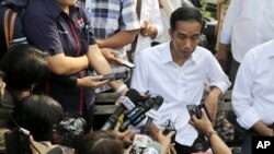 Presiden terpilih Joko Widodo berbicara dengan wartawan dalam kunjungannya ke Waduk Pluit di Jakarta (22/7). (AP/Dita Alangkara)