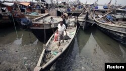 Burmeese displaced by recent violence carry their belongings as they arrive by boats to Thaechaung refugee camp, outside of Sittwe (formerly Akyab), the capital of Rakhine State, October 28, 2012. 