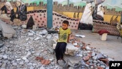  9 جولائی، 2024 کو وسطی غزہ کی پٹی میں نصیرات بے گھر ہونے والے لوگوں کو پناہ دینے والے اقوام متحدہ کے زیر انتظام اسکول میں ایک بچہ ملبے پر بیٹھا ہے۔ فوٹو اے ایف پی۔