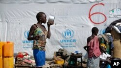 FILE - A South Sudanese refugee girl eats porridge, at the Imvepi intake center, where newly-arrived refugees are processed before being transferred to the nearby Bidi Bidi refugee settlement, in northern Uganda, June 9, 2017.