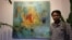 Chhim Sothy, a Cambodian artist, pose in front of his painting at the launching of his exhibition called "Consuming Passion" at the Plantation Hotel in Phnom Penh, Cambodia, on June 25, 2015. 