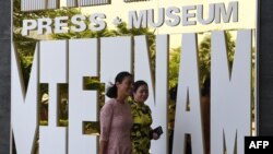 Women walk past the Vietnam Press Museum in Hanoi on July 16, 2020. - Vietnam's newly-opened Press Museum shows history of journalism in the communist country. (Photo by Nhac NGUYEN / AFP)
