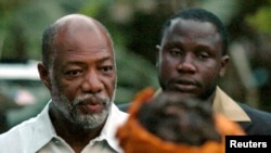 FILE - Varney Sherman (L) and his wife Joyce (front) arrive for a prayer service on the last night of election campaigning in Monrovia, 2005.
