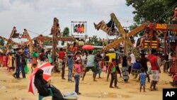 ស្រ្តី​ជនជាតិ​រ៉ូហ៊ីងយ៉ា អង្គុយ​នៅ​ក្រោម​ឆ័ត្រ​ខណ​ដែល​នាង​កំពុ​ងលក់ផ្លែឈើ​នៅ​កន្លែង​កម្សាន្ត​មួយ​ក្នុង​ជំរំ​ជន​ភៀស​ខ្លួន Kutupalong កាលពី​ថ្ងៃទី​២៣ សីហា ឆ្នាំ ២០១៨។