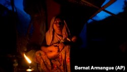 Seorang perempuan dari etnis minoritas Rohingya menggendong anaknya di tempat penampungan sementara setelah menyeberangi perbatasan dekat wilayah Gundum di Cox's Bazar, 2 September 2017.