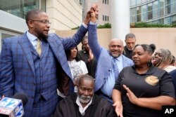 عدالت کے فیصلے کے بعد سیاہ فاموں کے کونسلر مالک شہباز(بائیں) اور ان کے ساتھ کونسلر ٹرینٹ والکر خوشی کا اظہار کر رہے ہیں۔ 21 مارچ 2024