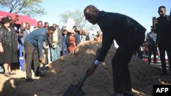 Botswana President Duma Boko throws sand onto the grave during the burial and memorial service of the late Pitseng Gaoberekwe in Metsiamanong village, Central Kalahari Game Reserve (CKGR), on Dec. 10, 2024.