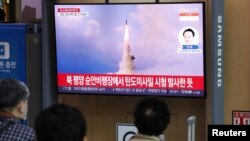 People watch a TV broadcasting a news report on North Korea's intercontinental ballistic missile (ICBM) test, in Seoul