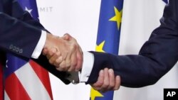 美国总统特朗普和法国总统马克龙在七国集团峰会的新闻发布会上握手（2019年8月26日）。