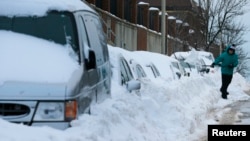 Peter Gonsiorowski works to shovel out his car following a winter blizzard in Somerville, Massachusetts, Jan. 28, 2015. 