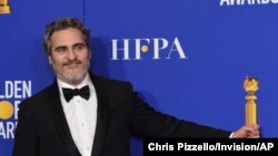 Joaquin Phoenix pretends to hold his award for best performance by an actor in a motion picture drama for ‘Joker’ in the press room at the 77th annual Golden Globe Awards at the Beverly Hilton Hotel Jan. 5, 2020.