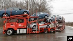 Un camion de transport automobile rempli de nouvelles voitures sort de l'usine General Motors de Lordstown, mardi 27 novembre 2018, à Lordstown, dans l'Ohio. 