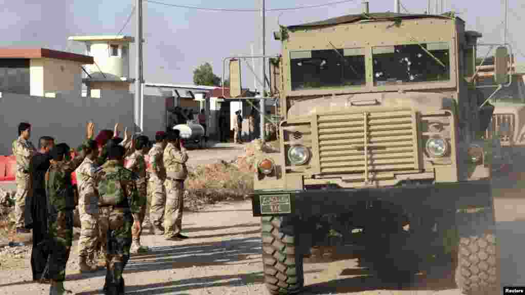 A convoy of Kurdish peshmerga fighters drives through Irbil after leaving a base in northern Iraq, on their way to Kobani, Syria, Oct. 28, 2014.
