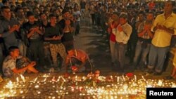 Para migran mengadakan penyalaan lilin untuk mengenang tewasnya 71 migran dalam sebuah truk di Austria, dalam acara di Budapest, Hungaria hari Jumat (28/8).