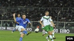 Pemain depan Italia, Antonio Cassano (kiri) saat mencetak gol dalam pertandingan melewat Irlandia utara (11/10).