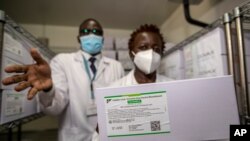 Technicians show a carton of AstraZeneca COVID-19 vaccine manufactured by the Serum Institute of India, inside a cold storage room at the central vaccine depot in Kitengela town on the outskirts of Nairobi, Kenya, March 4, 2021.