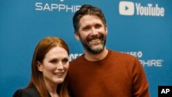 Julianne Moore, left, a cast member in "After the Wedding," poses with her husband, the film's writer/director Bart Freundlich, at the premiere of the film on the opening night of the 2019 Sundance Film Festival, Thursday, Jan. 24, 2019, in Park City, Utah.