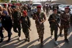 Fighters of Syrian Democratic Forces (SDF) take part in the funeral procession of Kurdish fighters who were killed during clashes in the northeastern Syrian town of Ras al-Ain, in the town of Qamishli, Oct. 22, 2019.