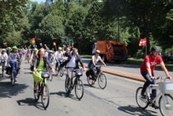 EU Ambassador to the U.S. Stavros Lambrinidis, center, and other EU diplomats carrying their countries’ flags as they ride along Massachusetts Avenue in Washington, July 25, 2019. (Delegation of the EU to the US)