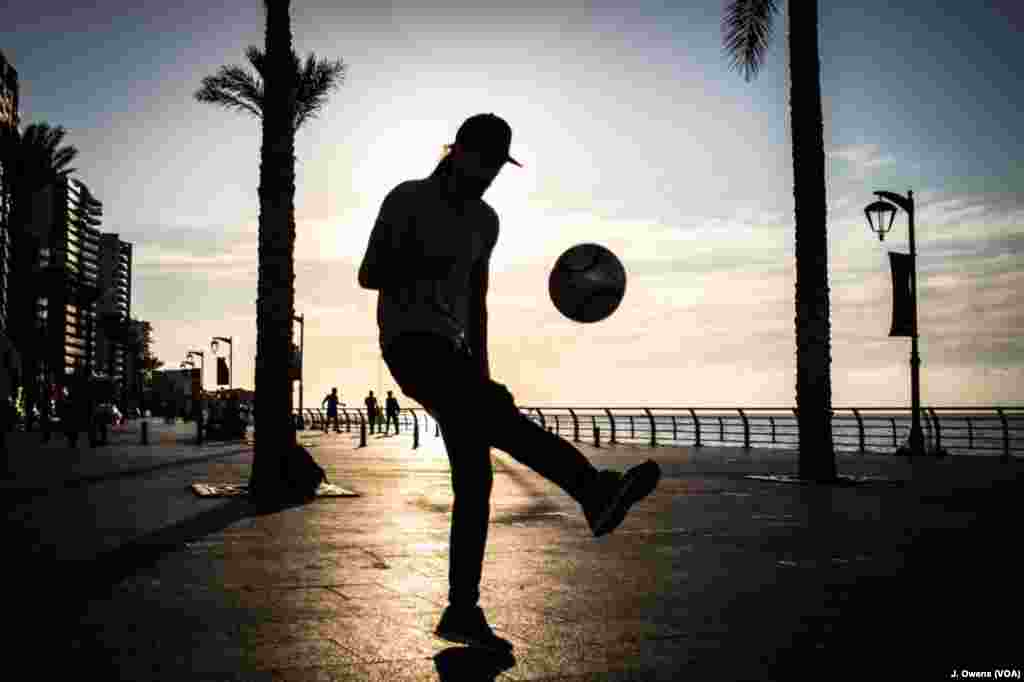 A group play football along Beirut's seafront. 