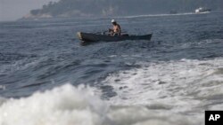 A man fishes on the Guanabara Bay in Rio de Janeiro, Brazil, Thursday, April 10, 2014. Many had hoped authorities tackle decades of neglect and poor planning that have blighted waterways, after Rio's Olympic committee pledged in writing that the pollution of Guanabara Bay will be fixed. (AP Photo/Silvia Izquierdo)