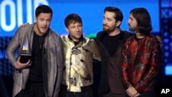 Dan Reynolds, dari kiri, Ben McKee, Daniel Platzman, dan Daniel Wayne Sermon dari Imagine Dragons menerima penghargaan untuk Grup Favorit atau Duo di penghargaan American Music Awards di Microsoft Theater di Los Angeles, 19 November 2017.