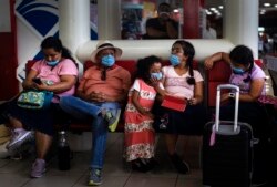 Tourists from Mexico wearing masks as a precaution against the spread of the new coronavirus, wait for their flight home, at the Jose Marti International Airport in Havana, Cuba, March 23, 2020.
