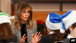 FILE - First lady Melania Trump joins local school students creating holiday decorations at the Salvation Army Clapton Center in London, Dec. 4, 2019. 