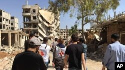 This photo released by the International Committee for the Red Cross shows the first humanitarian aid convoy in Daraya, Syria on Wednesday, June 1, 2016. It was the first aid to reach Daraya in four years. The U.N. estimates that 4,000 to 8,000 people currently live there. (ICRC via AP)