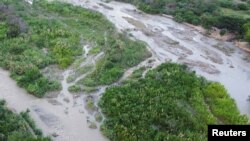 Orang-orang melintasi perbatasan antara Kolombia dan Venezuela, sebelum perbatasan dibuka kembali secara resmi, di Cucuta, Kolombia 25 September 2022. REUTERS/Leonardo Fernandez Viloria