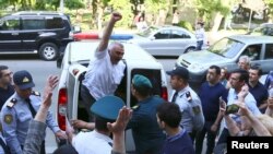 FILE - Azerbaijani journalist Afgan Mukhtarli greets supporters as he is taken to court in Baku, Azerbaijan, May 31, 2017.