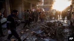 People check the aftermath of a car bomb blast in the city of Qamishli, northern Syria, Nov. 12, 2019.