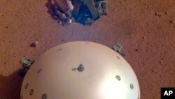 This photo made available by NASA on Tuesday, April 23, 2019 shows the Mars InSight lander's domed wind and thermal shield which covers a seismometer. (NASA/JPL-Caltech via AP)