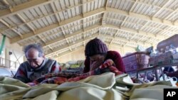 Evacuees Kazuko Hiraushi (r) and her husband Yoshidaka, who lost their house in the massive earthquake and tsunami that struck Japan a week earlier, cry after observing a minute's silence in memory of the victims, at an evacuation center near a devastated