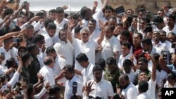 Sri Lanka's newly elected president Gotabaya Rajapaksa, center, greets people as he leaves after the swearing in ceremony Nov. 18, 2019.