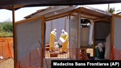 FILE - Health care workers from Medecins Sans Frontieres prepare isolation and treatment areas for their Ebola, hemorrhagic fever operations, in Gueckedou, Guinea. 