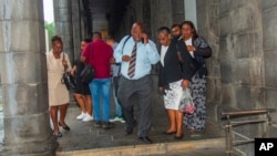 Des Chagossiens, menés par Olivier Bancoult (c) se trouvent devant le bureau du premier ministre mauricien à Port Louis, Maurice, le 3 octobre 2024, après avoir appris que le Royaume-Uni avait accepté de transférer la souveraineté des îles Chagos à l'île Maurice.