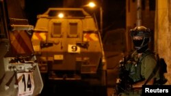 An Israeli soldier stands guard in the West Bank city of Hebron, June 15, 2014. 