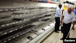 A worker checks empty shelves after removing processed meat products at a Pick n Pay Store in Johannesburg, South Africa, March 5, 2018, amid the country's worst listeria outbreak on record.