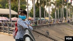 រូបឯកសារ៖ យុវតី​៣នាក់​ពាក់ម៉ាស់​ ​នៅច្រាំង​ទន្លេ​ចតុមុខ ខាង​មុខ​ព្រះបរមរាជវាំង​នៅ​ខាងមុខ​ព្រះបរមរាជវាំង ​ក្នុង​រាជធានី​ភ្នំពេញ កាលពី​ថ្ងៃទី​១១ ខែមីនា ឆ្នាំ២០២០ ខណៈដែល​វីរុស​កូរ៉ូណា ​Covid-19 កំពុង​ផ្ទុះ​ជុំវិញពិភពលោក។ (ទុំ ម្លិះ/VOA)