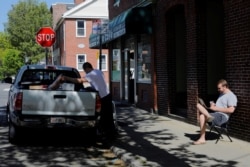 Jack Coopersmith sits outside his apartment and takes part in a remote meeting while working from home during COVID-19 outbreak, Cambridge, Massachusetts, May 22, 2020.
