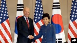Presiden Korea Selatan Park Geun-hye (kanan) berjabat tangan dengan Wakil Presiden AS Joe Biden di Seoul (6/12). (AP/Lee Jin-man)