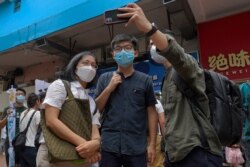 Hong Kong activist Joshua Wong poses for a photo with supporters after attending an activity for the upcoming Legislative Council elections in Hong Kong Saturday, June 20, 2020. Wong said Thursday that opposing a draft national security law for Hong…