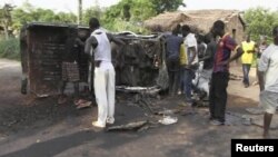 People gather around a burnt Seleka Rebel truck in Begoua, 17 km (10 miles) from capital Bangui, in this still image taken from video, Mar. 23, 2013.
