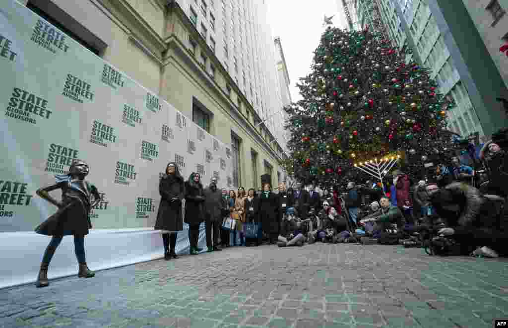 无畏女孩像在她的新家&mdash;&mdash;纽约证券交易所旁边亮相，人们参加揭幕活动。（2018年12月10日） 。