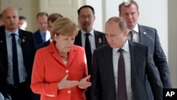 Russian President Vladimir Putin (R) and German Chancellor Angela Merkel speak to each other before the World Cup final between Germany and Argentina in Rio de Janeiro, Brazil.