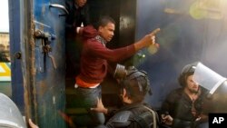 Egyptian riot police detain a man during clashes with supporters of ousted President Mohamed Morsi in the Nasr City district of Cairo, Egypt, Friday Jan. 10, 2014.