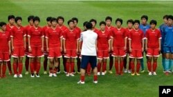 North Korean women's national soccer team players listen to head coach Kim Kwang Min after training session, Seoul World Cup stadium, South Korea, July 19, 2013.