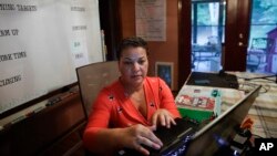 Aimee Rodriguez Webb works on her computer reading emails at her dining room table that she set up as a virtual classroom for a Cobb County school, on Tuesday, July 28, 2020, in Marietta, Ga. (AP Photo/Brynn Anderson)