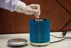 A laboratory staff member demonstrates testing for the COVID-19 virus at Suvarnabhumi Airport in Bangkok, July 3, 2020.